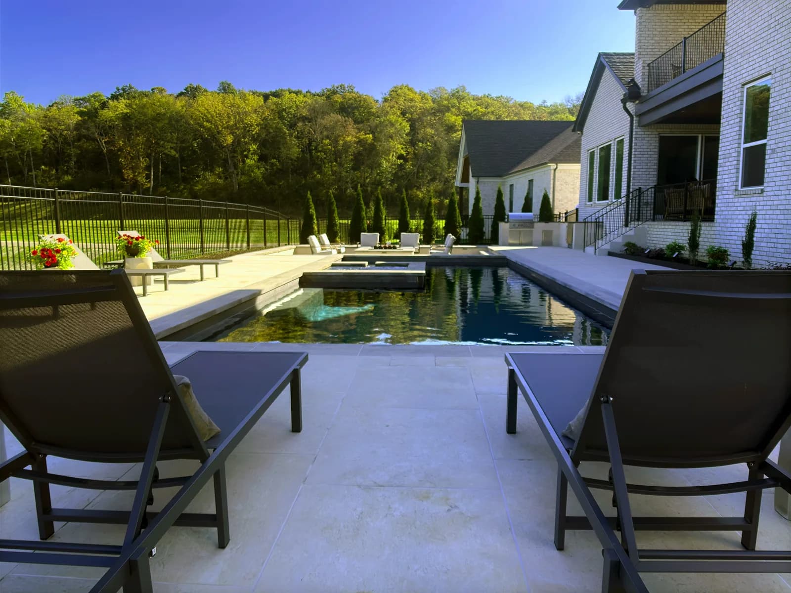 Backyard pool with loungers and paver decking beside a Middle Tennessee home