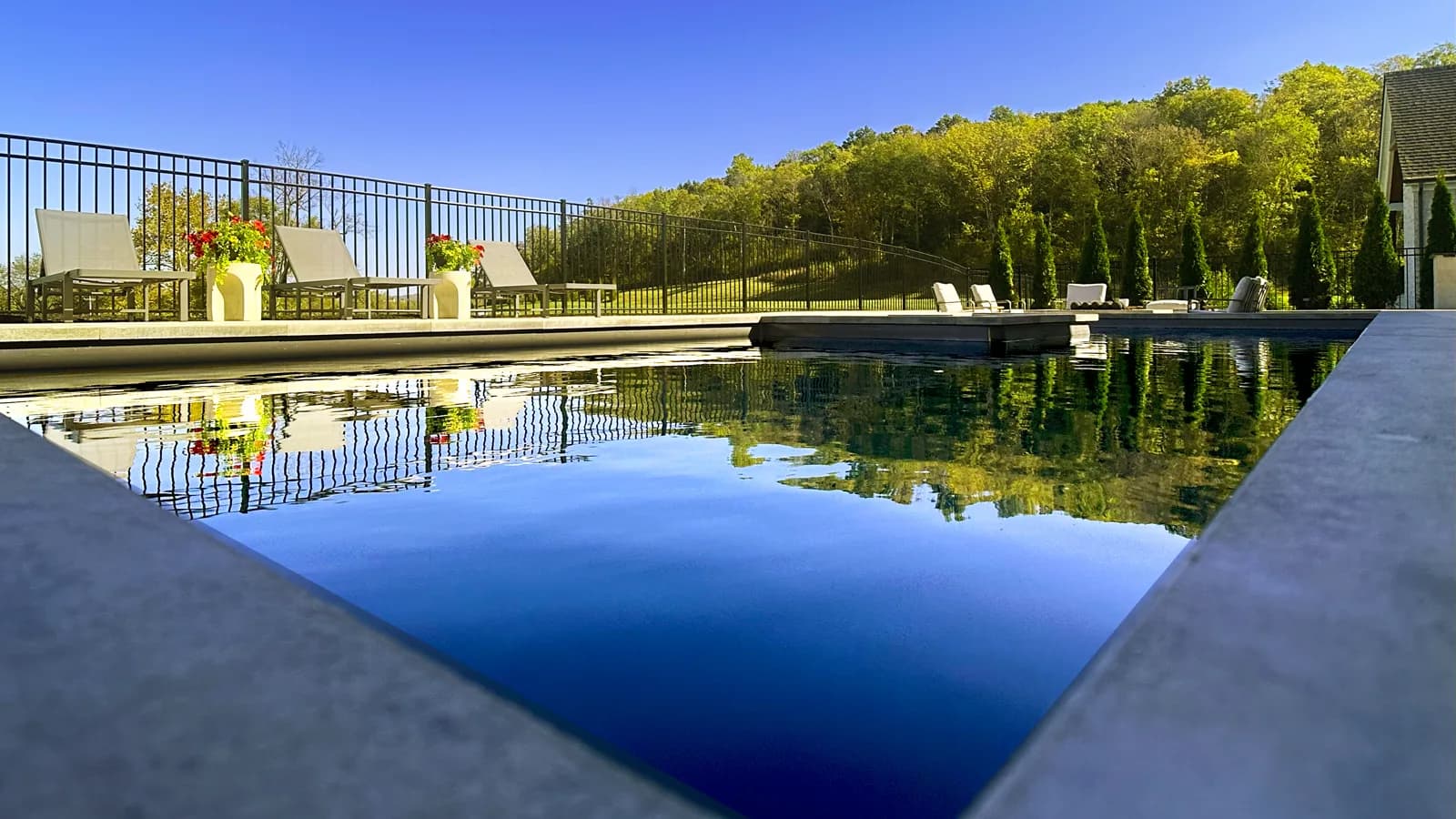 Close detail of an infinity edge spilling over a custom pool wall in Middle Tennessee