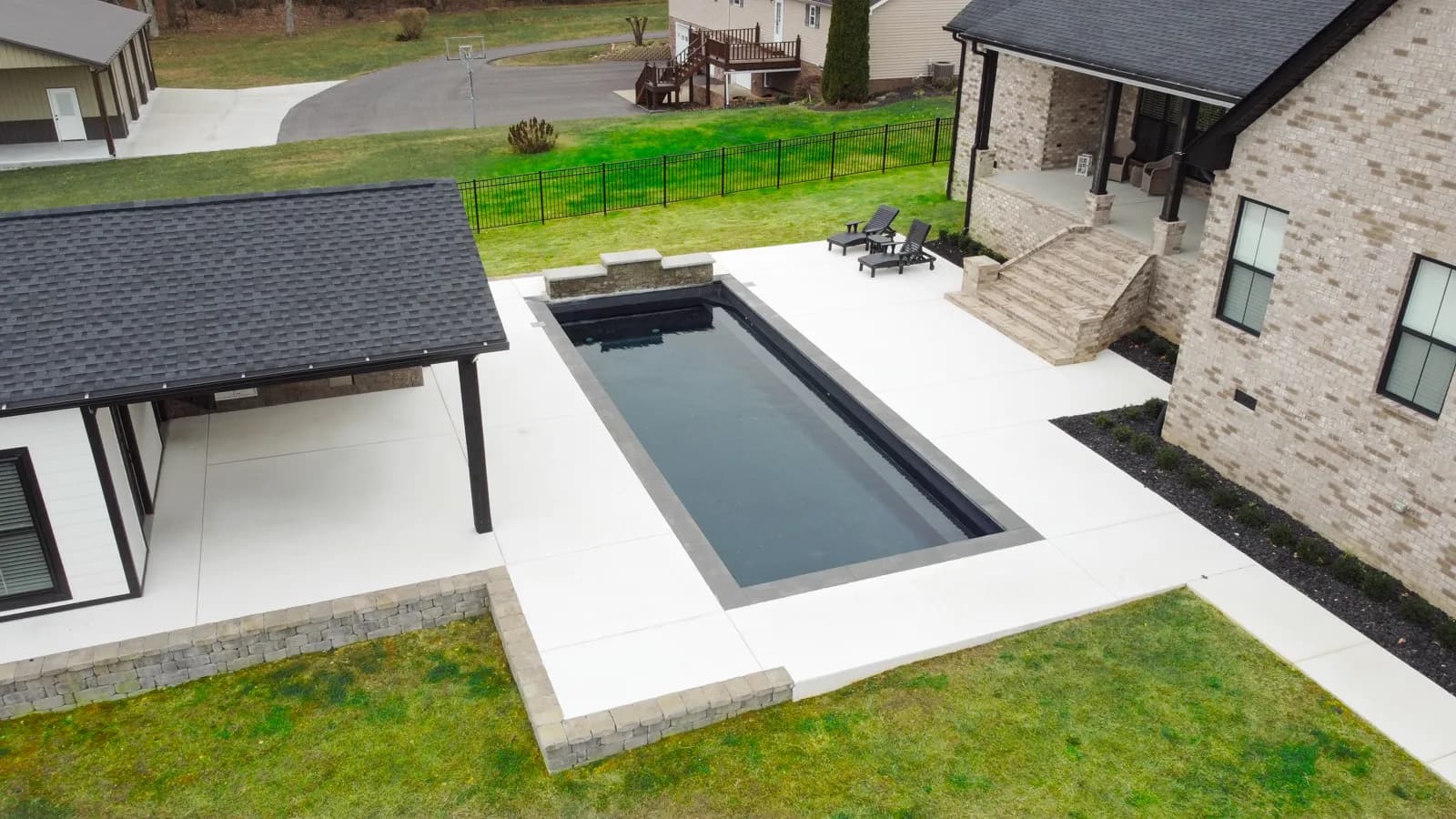Aerial view of a modern dark rectangular pool with a covered pavilion in Middle Tennessee